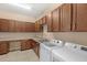 Spacious laundry room featuring tile flooring, stainless steel sink and modern washer and dryer at 290 Silver Maple Rd, Groveland, FL 34736