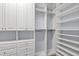 Large walk-in closet with custom white shelving and cabinetry creates ample storage and organization space at 290 Silver Maple Rd, Groveland, FL 34736