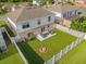 Aerial view of the backyard featuring a white fence, fire pit, and outdoor patio seating at 132 Spanish Bay Dr, Sanford, FL 32771