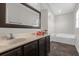 A bathroom featuring a white sink, large mirror, and tiled tub for a relaxing at-home spa experience at 132 Spanish Bay Dr, Sanford, FL 32771