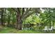 Scenic backyard view with two white rocking chairs near a tranquil pond at 2620 Osceola Bluff Ln, Geneva, FL 32732