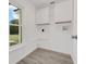 Bright laundry room with wood-look tile flooring, utility sink hookups, and storage cabinets at 2620 Osceola Bluff Ln, Geneva, FL 32732