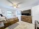 Bright bedroom featuring a large TV and ample dresser storage at 100 E Oak Terrace Dr # G1, Leesburg, FL 34748