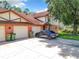 Two-story building exterior with attached garages and a car parked in front at 100 E Oak Terrace Dr # G1, Leesburg, FL 34748