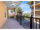 A covered balcony with a ceiling fan overlooking a parking lot and a beautiful residential community at 913 Lotus Vista Dr # 101, Altamonte Springs, FL 32714