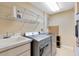 A laundry room featuring a washer, dryer, utility sink, shelves, and a water heater at 913 Lotus Vista Dr # 101, Altamonte Springs, FL 32714