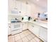 White kitchen with appliances, tile floor, and ample cabinetry at 113 Rogues Retreat, Davenport, FL 33897