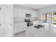 Bright kitchen with stainless steel appliances, white cabinetry, and a view of the backyard through sliding glass doors at 349 River Front Way, Edgewater, FL 32141