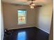 Bedroom with dark hardwood floors and natural light coming through the large window at 806 Grantham Dr, Kissimmee, FL 34758