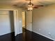 Bedroom featuring closet, dark hardwood floors, neutral walls, and ceiling fan at 806 Grantham Dr, Kissimmee, FL 34758