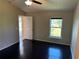 Sunlit bedroom featuring wood floors, a ceiling fan, and a view of the outdoors at 806 Grantham Dr, Kissimmee, FL 34758