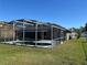 View of the screened-in pool, featuring an attached home with a well-manicured lawn at 806 Grantham Dr, Kissimmee, FL 34758