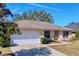 Single-story home with a white garage door and neatly landscaped front at 4490 Treasure Cay Rd, Tavares, FL 32778