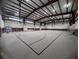 A large indoor gymnasium featuring basketball hoops, a carpeted floor, and ample lighting at 4490 Treasure Cay Rd, Tavares, FL 32778