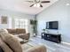 Bright living room features a large sectional sofa and flat-screen TV at 4490 Treasure Cay Rd, Tavares, FL 32778