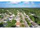 A high aerial shot of the neighborhood shows many green treetops, waterways, and homes with solar panels at 10332 Olcot St, Orlando, FL 32817