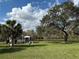Scenic view of well-maintained grounds with a gazebo, lush grass, mature trees, and a serene lake at 4901 Pleasant Hollow Trl, Lakeland, FL 33811