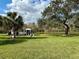 Scenic view of well-maintained grounds with a gazebo, lush grass, mature trees, and a serene lake at 4901 Pleasant Hollow Trl, Lakeland, FL 33811