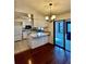 Bright eat-in kitchen features white cabinets, a breakfast bar, a chandelier and a sliding door at 4901 Pleasant Hollow Trl, Lakeland, FL 33811