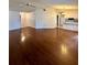 Spacious living room featuring gleaming hardwood floors and neutral wall color that flows into the kitchen at 4901 Pleasant Hollow Trl, Lakeland, FL 33811