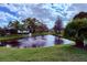 Scenic view of a pond with fountain and mature landscaping and community homes at 4901 Pleasant Hollow Trl, Lakeland, FL 33811