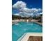 Large community pool with lounge chairs and sparkling blue water under a partly cloudy sky at 4901 Pleasant Hollow Trl, Lakeland, FL 33811