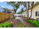 A backyard patio with a stone fireplace and mature trees offers a serene outdoor retreat at 910 Cypress Ave, Saint Cloud, FL 34769