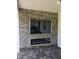 Outdoor entertainment area with a stone wall and electric fireplace at 6979 Big Bend Dr, Saint Cloud, FL 34771