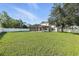 A spacious backyard with a large lawn, fenced perimeter, and a screened-in porch at 724 Tahiti Dr, Kissimmee, FL 34758