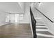 Bright entryway featuring wood-look flooring, staircase with dark railing, and neutral paint color at 724 Tahiti Dr, Kissimmee, FL 34758