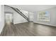 Spacious living room featuring light gray wood-look floors, staircase, and arched entry at 724 Tahiti Dr, Kissimmee, FL 34758