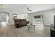 Open-concept living room featuring wood floors, a ceiling fan, and sliding glass doors leading to the pool area at 724 Tahiti Dr, Kissimmee, FL 34758