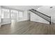 Open-concept living room with light gray wood floors and staircase with black railing at 724 Tahiti Dr, Kissimmee, FL 34758