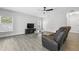 Cozy living room with wood-look flooring, a brown reclining couch, and natural lighting at 724 Tahiti Dr, Kissimmee, FL 34758
