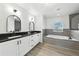Bright main bathroom with dual sinks, granite counters, soaking tub, and updated fixtures at 724 Tahiti Dr, Kissimmee, FL 34758