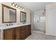 Bathroom featuring a glass enclosed shower, dual sinks, marble countertops, and wood cabinets at 7801 Belvoir Dr, Orlando, FL 32835