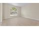 Sunlit bedroom featuring light wood-look floors and a large arched window with a view at 7801 Belvoir Dr, Orlando, FL 32835