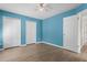 Bedroom featuring blue walls, wood-look floors, and double closets at 7801 Belvoir Dr, Orlando, FL 32835