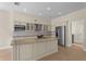 Open kitchen with granite counters, stainless steel appliances, island sink, and a view of the adjacent spaces at 7801 Belvoir Dr, Orlando, FL 32835