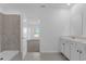 Bright bathroom featuring a dual sink vanity, walk-in shower, and tile flooring at 4945 Worchester Dr, Kissimmee, FL 34746