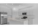 Modern kitchen with stainless steel appliances, quartz countertops, kitchen island, and white cabinets at 4945 Worchester Dr, Kissimmee, FL 34746