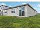 Lush green backyard featuring a sliding glass door and a cozy patio area at 1390 Current Pl, Haines City, FL 33844