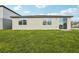 Spacious backyard view with well-maintained lawn and the home's exterior at 1390 Current Pl, Haines City, FL 33844