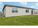 Well-manicured backyard with green grass and a glimpse of the home's exterior at 1390 Current Pl, Haines City, FL 33844