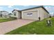 Attractive home featuring a brick paver driveway, a one car garage, and green lawn at 1390 Current Pl, Haines City, FL 33844