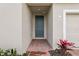 Inviting entryway featuring a covered porch with brick pavers and a stylish front door at 1390 Current Pl, Haines City, FL 33844