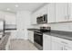 Bright kitchen featuring white cabinets, stainless steel appliances, and granite countertops at 1390 Current Pl, Haines City, FL 33844