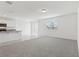 Open-concept living space with carpet flooring, leading to a modern kitchen with white cabinets at 1390 Current Pl, Haines City, FL 33844