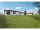 Expansive backyard featuring a lush lawn with a view of the house and a tree at 1542 Mermaid Way, Haines City, FL 33844