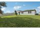 Serene backyard featuring a lush lawn, mature tree, and a view of the home's exterior at 1542 Mermaid Way, Haines City, FL 33844